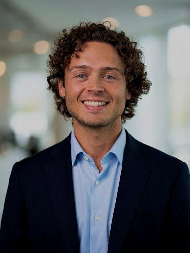 Gabriel Olivencia, smiling, in a dark blazer and light-blue shirt